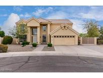 Two-story home featuring a tan exterior, manicured landscaping, and a spacious two-car garage at 4106 E Lavender Ln, Phoenix, AZ 85044