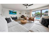 Inviting living room with fireplace, sliding doors to outdoor patio and pool, and comfortable seating at 5001 E Redfield Rd, Scottsdale, AZ 85254