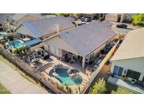 Aerial view of a backyard with a pool, patio, and outdoor kitchen, ideal for entertaining and relaxation at 1437 E Glenhaven Dr, Phoenix, AZ 85048
