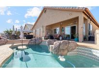 Inviting backyard pool featuring rock accents and a swim-up table, perfect for outdoor relaxation and entertainment at 1437 E Glenhaven Dr, Phoenix, AZ 85048