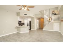 Open-concept living space with modern kitchen, staircase, and wood-look flooring at 16 W Encanto Blvd # 22, Phoenix, AZ 85003