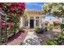 Charming home featuring a tile roof, lush landscaping, and a welcoming front entrance with a black door at 1978 E Carver Rd, Tempe, AZ 85284