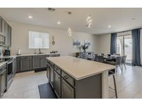 Modern kitchen with stainless steel appliances, gray cabinets, and a center island at 2775 N Mulberry Pl, Casa Grande, AZ 85122