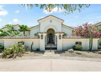 Elegant home featuring a gated entrance and lush landscaping, creating a welcoming approach at 7003 E Avenida El Alba --, Paradise Valley, AZ 85253