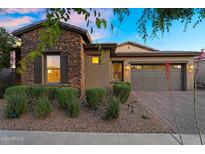 Beautiful single-story home with stone accents, manicured landscaping, and a charming paver driveway at 10741 E Palladium Dr, Mesa, AZ 85212