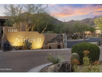 Elegant community entrance featuring desert landscaping, stone accents, and well-lit signage at sunset at 13450 E Via Linda -- # 2041, Scottsdale, AZ 85259