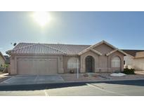 Charming single-story home with a tile roof, arched entryway, and well-maintained front yard landscaping at 6942 S Championship Dr, Chandler, AZ 85249