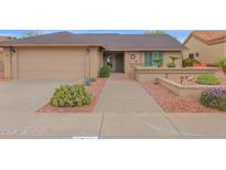 Inviting front yard with desert landscaping, manicured bushes, and a well-maintained walkway to the front door at 9740 W Rockwood Dr, Peoria, AZ 85382