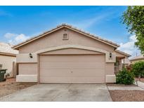A well-maintained garage features a neutral color scheme and a clean concrete driveway under a bright blue sky at 10407 W Reade Ave, Glendale, AZ 85307