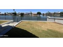 Waterfront property featuring an spacious grassy yard enclosed with a fence and a beautiful lake view at 1414 N Palmsprings Dr, Gilbert, AZ 85234