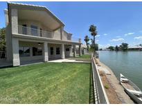 View of the home's backyard, featuring a lush lawn and waterfront access at 1414 N Palmsprings Dr, Gilbert, AZ 85234