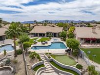 This backyard features a pool, hot tub, putting green, covered patio, and mountain views at 15645 S 17Th St, Phoenix, AZ 85048