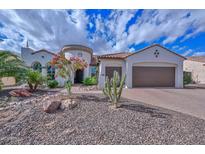 Charming stucco home featuring a tile roof, desert landscaping, and a spacious three-car garage at 16445 W Berkeley Rd, Goodyear, AZ 85395