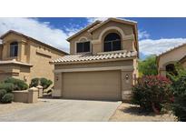 Charming two-story home featuring a two-car garage and a well-maintained desert landscape under a sunny sky at 1909 N 106Th Ave, Avondale, AZ 85392