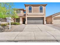 Inviting two-story home with a well-maintained front yard, desert landscaping, and a spacious two-car garage at 2418 W White Feather Ln, Phoenix, AZ 85085