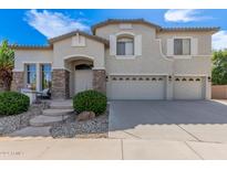 Charming two-story home featuring a three car garage, stone accents, and lovely landscaping at 4490 S Rio Dr, Chandler, AZ 85249