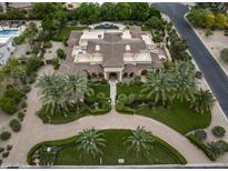 Expansive estate featuring a tile roof, circular driveway, lush landscaping, and a sparkling pool at 6852 E Fanfol Dr, Paradise Valley, AZ 85253