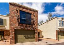 Two-story townhouse featuring a private garage and balcony on the front brick elevation at 820 W University Dr # 4, Tempe, AZ 85281