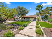 Charming home featuring a tile roof, lush landscaping, and a stone tile walkway leading to the inviting front entrance at 8814 N 86Th St, Scottsdale, AZ 85258