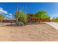 Inviting two-story home with desert landscaping, mature trees and a circular driveway at 9137 E Odessa St, Mesa, AZ 85207