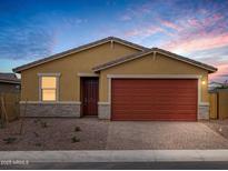 Inviting single-story home with a brick-lined driveway, a red garage door, and desert-friendly landscaping at 35445 N Seedling St, San Tan Valley, AZ 85144