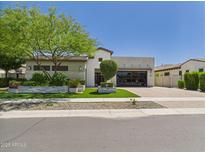 Stunning single-story home with lush landscaping, modern design, and a spacious driveway at 4571 S Pinaleno W Dr, Chandler, AZ 85249