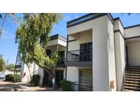 A clean two-story condo with a balcony, green tree, black railings, and a staircase at 740 W Elm St # 264, Phoenix, AZ 85013