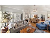 Bright living room featuring hardwood floors, a neutral color palette, fireplace and shuttered windows at 7272 E Gainey Ranch Rd # 48, Scottsdale, AZ 85258
