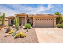 Inviting front exterior with desert landscaping and a two-car garage at 10861 E Olla Ave, Mesa, AZ 85212