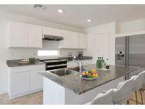Modern kitchen features stainless steel appliances, gray countertops, and white cabinets at 1173 N 13Th St, Coolidge, AZ 85128