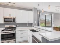 Modern kitchen featuring stainless steel appliances, white cabinets, and a stylish countertop at 2307 W Kristina Ave, San Tan Valley, AZ 85144