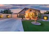 Charming single-story home boasting manicured turf and lush landscaping at twilight at 3379 E San Pedro Ave, Gilbert, AZ 85234