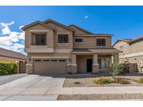 Two-story home featuring a two-car garage, desert landscaping, and a welcoming covered porch at 396 S 166Th Dr, Goodyear, AZ 85338