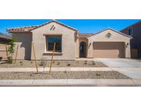 Charming single-story home with stucco siding, tile roof, desert landscaping, and attached garage at 662 W Rock Needle Trl, Apache Junction, AZ 85120