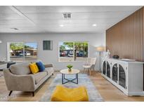 Modern living room featuring stylish furnishings, wood accent wall, and bright natural light at 7836 E Juanita Ave, Mesa, AZ 85208