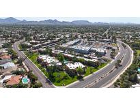 An elevated view showcasing a residential complex near stores, featuring mature trees and accessible roads at 8260 E Arabian Trl # 257, Scottsdale, AZ 85258