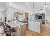 Bright, open kitchen with marble countertops, white cabinets, modern appliances, and terracotta tile flooring at 9736 E Turquoise Ave, Scottsdale, AZ 85258