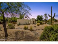 Stunning desert landscaping surrounds the unique exterior of this single-story home at 13034 N 69Th St, Scottsdale, AZ 85254