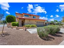 Two-story home featuring a charming front yard, desert landscaping, and a two-car garage at 1435 E Rancho Dr, Phoenix, AZ 85014
