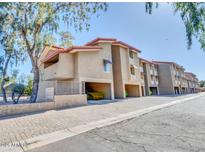 View of the condos with personal carport spaces under the units and red tile roofing at 151 E Broadway Rd # 206, Tempe, AZ 85282