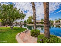 Serene view of a pond surrounded by lush greenery and beautiful homes at 20740 N 62Nd Ave, Glendale, AZ 85308