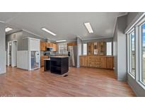 Bright kitchen featuring an island, stainless steel appliances, and wood cabinets at 2121 N Center St # 166, Mesa, AZ 85201