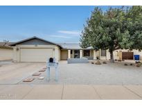 Charming single-story home showcasing desert landscaping, a mature shade tree, and a two-car garage at 2609 N Pleasant Dr, Chandler, AZ 85225
