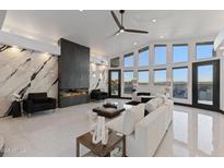 Airy living room with a modern fireplace, floor-to-ceiling windows, and stylish contemporary furnishings at 27 W Cochise Dr, Phoenix, AZ 85021