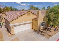 Inviting tan home with a two-car garage, a well-maintained yard, and a tile roof at 3252 E Maldonado Dr, Phoenix, AZ 85042