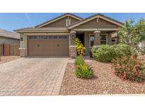 Charming single-story home features a brick driveway, two-car garage, and a beautifully landscaped front yard at 686 N 152Nd Dr, Goodyear, AZ 85338