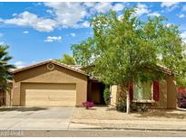 Charming single-story home featuring a two-car garage, desert landscaping, and a mature shade tree in the front yard at 7310 W Pioneer St, Phoenix, AZ 85043
