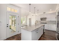 Bright kitchen with white cabinets, granite countertops, and a stainless steel sink and appliances at 122 W Cottage Ln, Tempe, AZ 85282