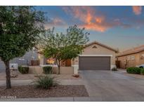 Charming single-story home with manicured front yard and two-car garage under a colorful dusk sky at 20848 E Desert Hills Blvd, Queen Creek, AZ 85142