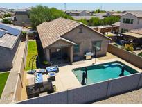 Inviting backyard with a sparkling pool, lounge area, BBQ, and a well-manicured yard offers ideal outdoor enjoyment at 26232 N 121St Ln, Peoria, AZ 85383